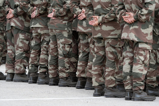 Soldiers in a relaxed position during the ceremony. Military camouflage outfit.