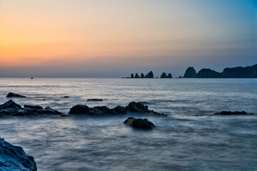 淡い色の背景と突き出た岩