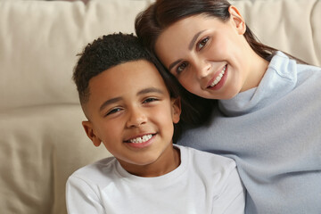 Mother with her African American son on sofa. International family