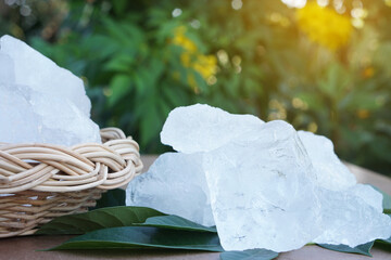 White crystal alum stone or Potassium alum on green leaves. Chemical compound. Useful for beauty...