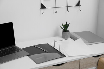 File folder with punched pockets on white table in office