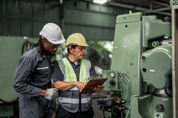 Fototapeta premium Engineering technicians inspect and assess the reliability of printed circuit assembly boards in manufacturing machine. Identifying errors, impaired, wear then record and report issues to supervisors