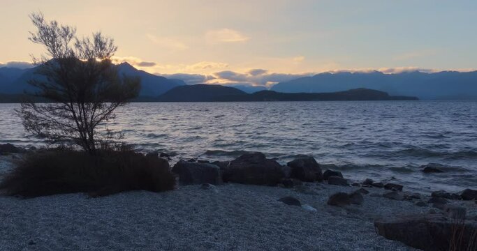 Aerial: wind over Lake at sunset, Manapouri, New Zealand