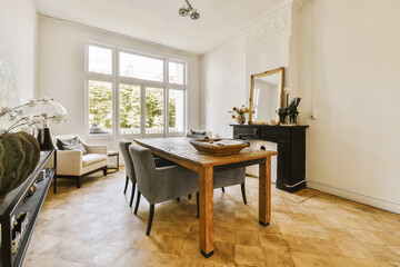 a dining room with wood flooring and large windows looking out onto the trees in the photo is taken from inside