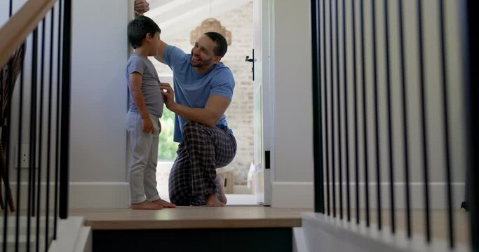 Happy, measuring height and a father with a child writing growth progress on a home wall. Laughing, pride and a dad drawing results of a kid measurement in a house to check for growing together