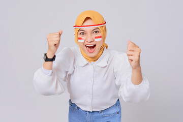 Excited young Asian Muslim woman in hijab celebrate Indonesian independence day on 17 August...