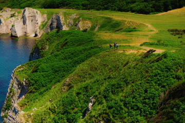 Coastal rocky landscape on summer sunny day with group of hikers