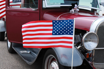 A red Ford 1929 Model A Pickup with an American flag flapping in the wind.