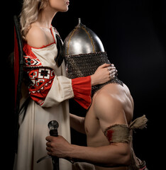 Young viking on his knees before beautiful wife