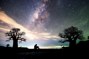 Naklejka na ściany i meble Lonely man, hopeless, heartbroken. At night, the milky way and the stars are beautiful.