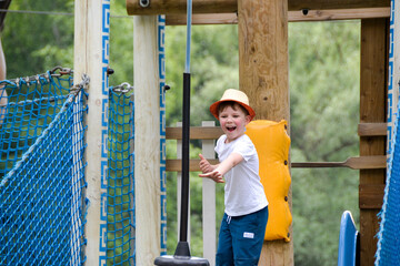 adventure climbing high wire park - people on course in mountain helmet and safety equipment.