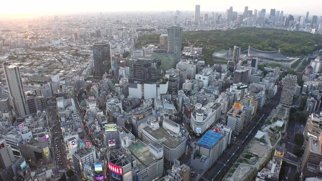 SHIBUYA, TOKYO, JAPAN - MAY 2023 : Aerial high angle view of SHIBUYA CROSSING in sunset time. View of building and street at crowded downtown. Japanese urban city life and metropolis concept 4K video.