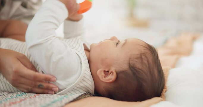 baby child, rattle toys and bed with mother, playing or care in family house for learning with childhood development. Infant kid, woman and excited for games, bonding and happy with mama in nursery