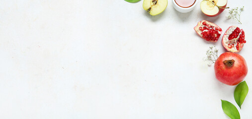 Ripe pomegranates, apples, flowers and honey on white background with space for text. Rosh Hashanah (Jewish New Year) celebration