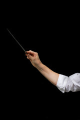 arm of male conductor with baton isolated on black background