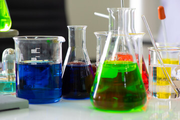 Close up view revealed an enchanting sight of beakers and flasks in a myriad of colors their glass surfaces illuminated by a soft, gentle light among an atmosphere of scientific.