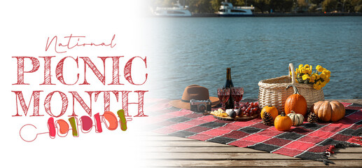 Banner for National Picnic Month with tasty food and wine on plaid near river