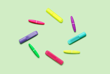 Frame made of colorful markers on green background
