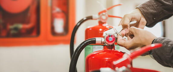 Fire extinguisher has hand engineer checking safety pin and pressure gauges fire extinguishers...