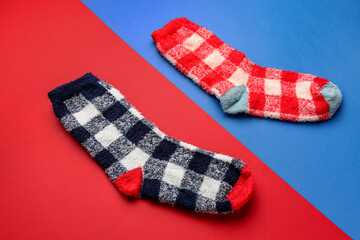 Pair of warm socks on color background