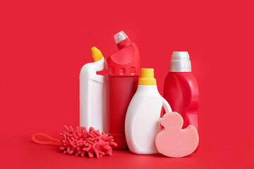 Different cleaning supplies on red background