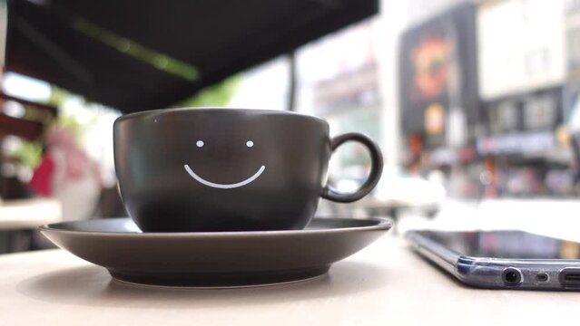 black coffee cup with smile shape design on it 