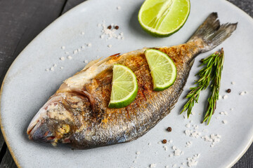 Plate with tasty grilled dorado fish on table