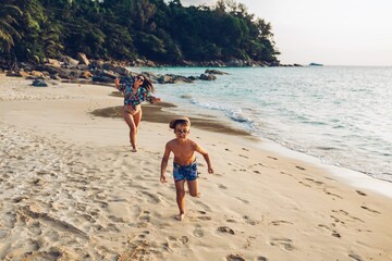 Toddler and mother running on the beach 