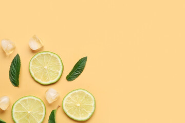 Lime slices with ice cubes and mint on orange background
