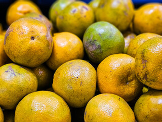Pile of Mandarin oranges in a supermarket local market in Thailand, Bunch of organic citrus ready to eat. Fresh Mandarin orange background