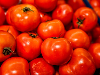 Close-up Pile of red tomatoes in a supermarket local market, Bunch of organic tomatoes. Fresh ripe tomatoes Full frame background