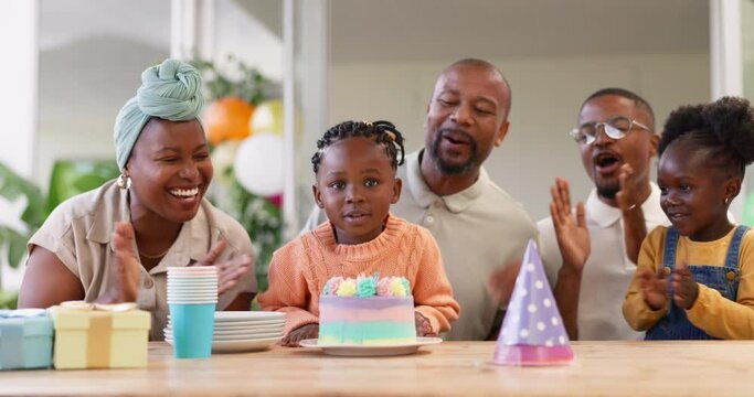 Birthday, children party and clapping with a black family in celebration of a girl child in their home. Parents, grandparents and applause with kids blowing candles on a cake at a milestone event