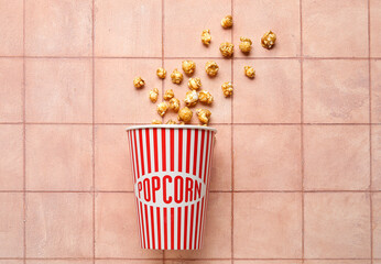 Bucket with tasty popcorn on pink tile background