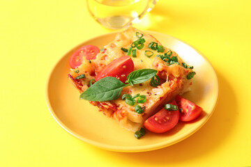 Plate of pasta with tomato sauce and cheese on yellow background