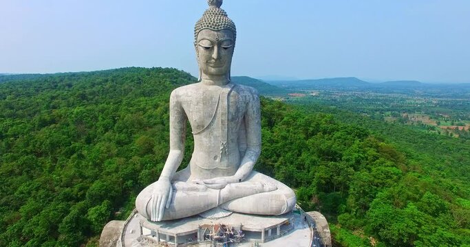aerial view Big white buddha statue on mountain for thai people travel visit and respect .praying at Wat Roi Phra Phutthabat Phu Manorom on May 15, 2017 in Mukdahan, Thailand..Big Buddha Wat Phu