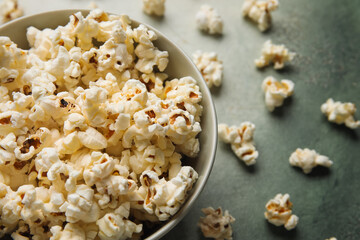 Bowl with tasty popcorn on grey background
