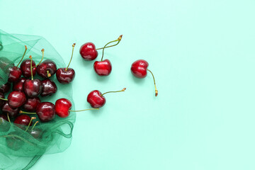 Obraz na płótnie Canvas Eco bag with sweet cherries on turquoise background