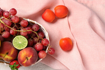 Wicker bowl with different fresh fruits, closeup