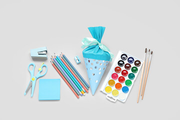 Blue school cone with different stationery on grey background