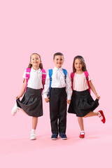 Fototapeta premium Little schoolchildren on pink background