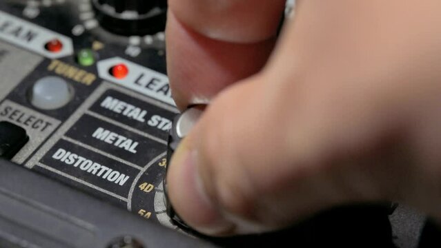Man adjusting sound knobs on guitar amplifier. 4k video footage UHD 3840x2160