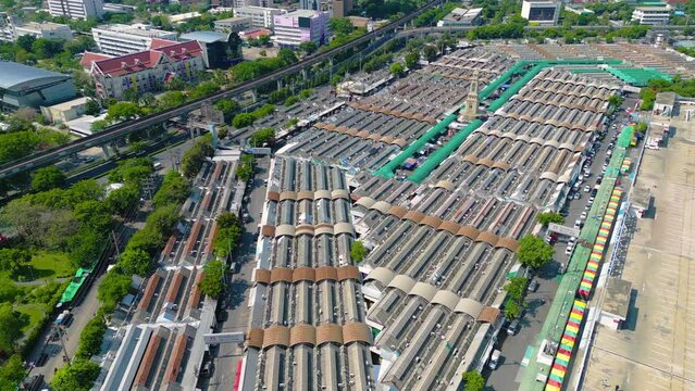 Aerial top view of Chatuchak Weekend street market, the largest market in Bangkok, Thailand, rooftops and parking area. Tents with retail shops on travel on holiday, vacation concept. Tourists area.