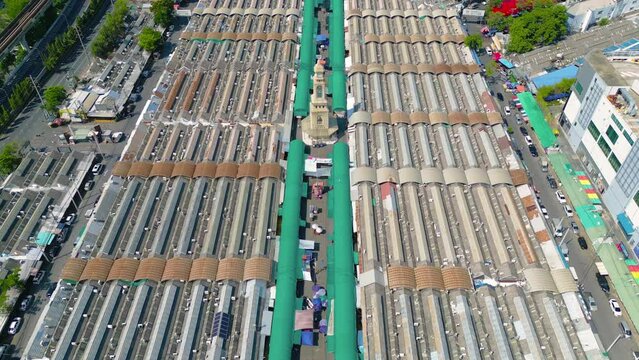 Aerial top view of Chatuchak Weekend street market, the largest market in Bangkok, Thailand, rooftops and parking area. Tents with retail shops on travel on holiday, vacation concept. Tourists area.