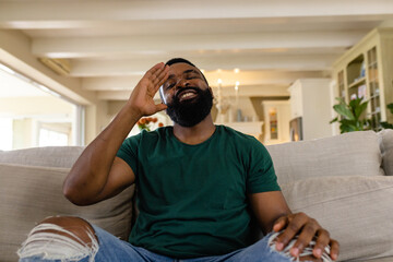 African american man making video call in living room