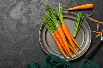 Plate of fresh carrots on black textured background