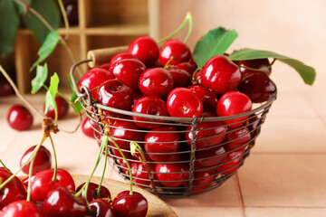 Basket with sweet cherries on pink tile table