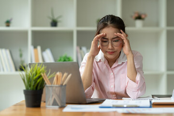 Cropped image of asian businesswoman analyzing paperwork using laptop to actively search for information tense expressions at the office.