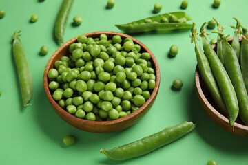 Bowls with fresh green peas on color background