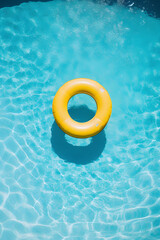 yellow donut shaped inflatable circle floats in the clear pool water background