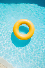 yellow donut shaped inflatable circle floats in the clear pool water background - obrazy, fototapety, plakaty